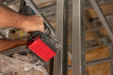 Primer plano manos con herramienta de trabajo, atornillador , construcci&oacute;n en seco