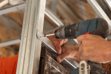 Primer plano manos con herramienta de trabajo, atornillador , construcci&oacute;n en seco