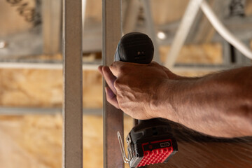 Primer plano manos con herramienta de trabajo, atornillador , construcci&oacute;n en seco