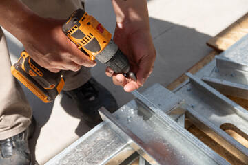 Primer plano manos con herramienta de trabajo, atornillador , construcci&oacute;n en seco