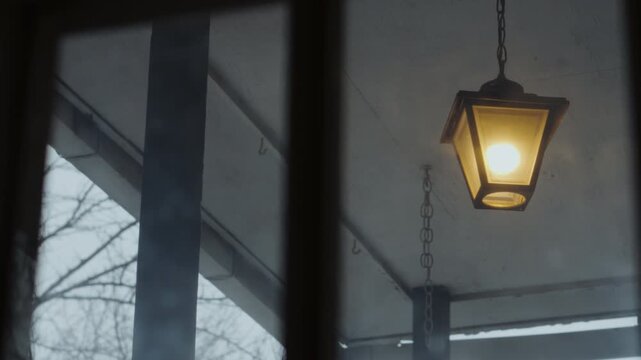 Swinging porch lamp swaying on an ominous breeze