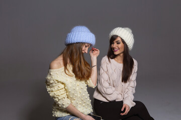 Vibrant and Energetic Portrait of Two Female Models with Bright Smiles and Perfect Teeth, Posing in Warm Woolen Accessories for an Autumn or Winter Seasonal Campaign