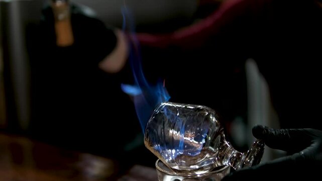 Bartender performing flair bartending with bottles and fireworks in slow motion. High quality 4k footage