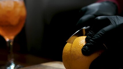 Aperol in a glass preparation hands slicing ripe, juicy orange cutting board. bright citrus fruit is freshly cut, showcasing its natural texture, freshness, vibrant color in detailed macro shot. 
