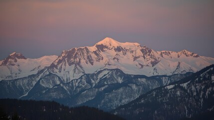 A breathtaking view of towering, snow-covered mountain peaks under a soft pastel sky.