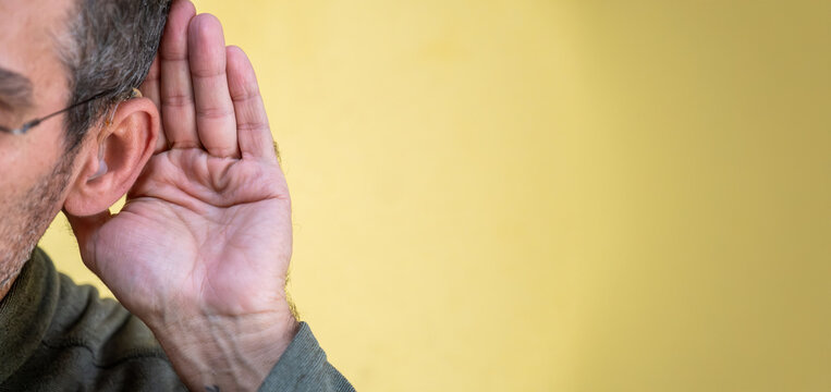 Man cupping ear listening to sound or gossip