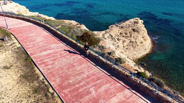 Persona mayor aprendiendo a volar un dron junto al mar