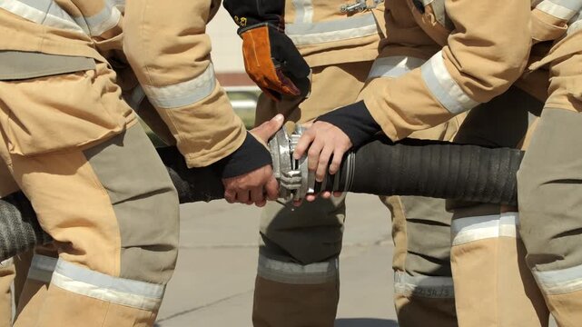 Firefighting Team Securing Heavy Water Hose