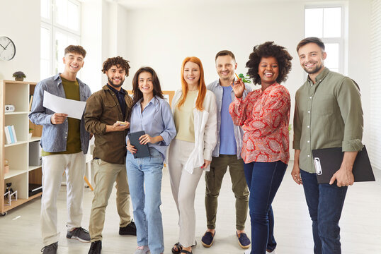 Portrait of a diverse and multiethnic group of students and colleagues in an office, showcasing happy teamwork. The people represent a team working together in a professional environment.