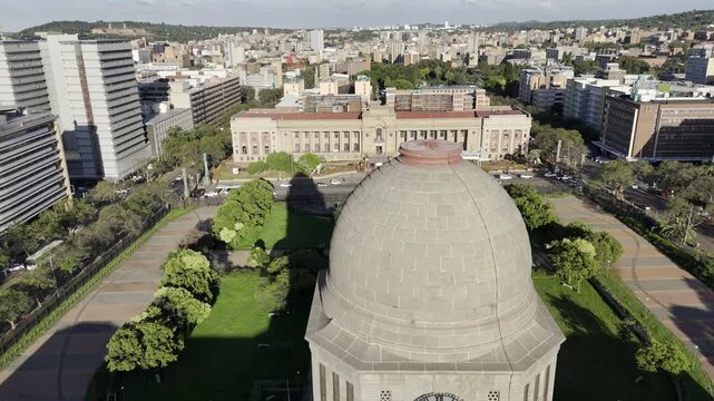 Drone orbits to the left in medium shot of the city hall tower in the late afternoon in Pretoria, South Africa