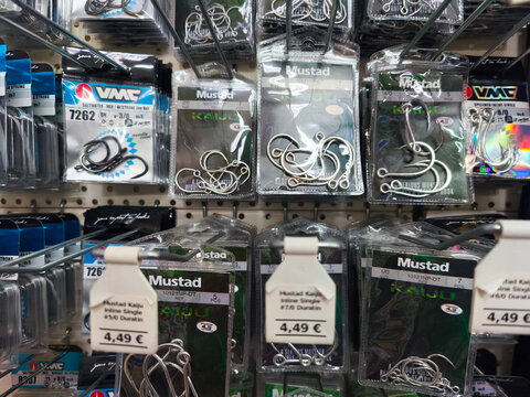 Potsdam, Germany - November 01, 2025: Fishing hooks displayed on store shelves, featuring Mustad and VMC brands, showcasing various sizes and types for anglers, perfect for fishing enthusiasts