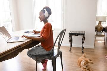 Positive young African freelancer woman working at home