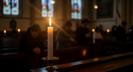 Candle glowing during solemn gathering in church with people praying  