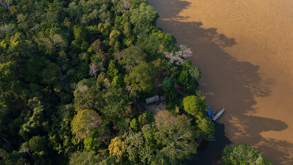 Drone view of the Madre de Dios River, a wide tropical waterway flowing through the Peruvian Amazon, surrounded by dense rainforest and natural wildlife habitat