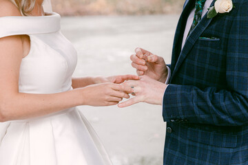 Couple exchanging wedding rings in a beautiful outdoor setting during a heartfelt ceremony