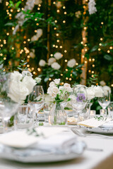 Elegant dining setup with floral decorations and warm lighting for a wedding reception in a beautiful venue