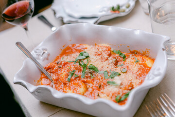 Delicious ravioli served with rich tomato sauce and fresh herbs at a cozy dining table