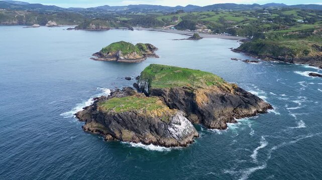 Chiloe Island, Chile: Cinematic Orbit aerial drone footage above islet by Pu&ntilde;ihuil coast of Ancud in Chiloe island, Lake District of Chile on sunny day in south Amercia by Pacific ocean