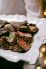 Perfectly cooked beef slices served on an elegant white platter at a festive gathering