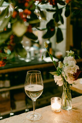 Elegant wine glass and floral arrangement on a restaurant table at night