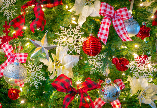 Christmas Tree close up with white Poinsettias, red and white bows and snowflakes
