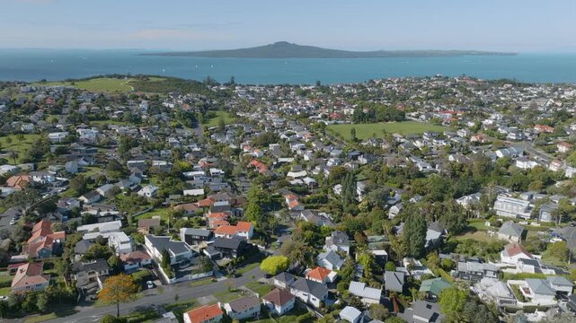 Aerial view of Auckland suburb with Rangitoto Island in the background, New Zealand. The clip shows Mission Bay residential area and the island in the distance.