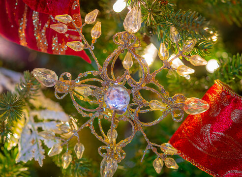 Golden and glittery Christmas ornament close up hanging on Christmas tree