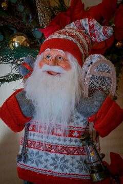 Christmas Santa  that has been snowshoeing with Poinsettias and wreath, close-up