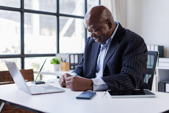 Sad and frustrated man feeling tired and worried about a problem sitting at office with laptop,stressed 60 year old male having problems reading bad news online, email notification about debt
