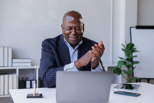 Portrait of African American senior man using laptop working and talk in open office in contemporary inclusive business setup
 - Powered by Adobe
