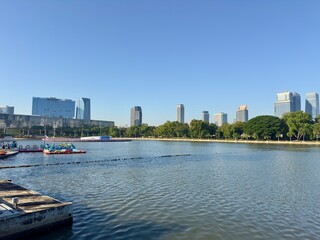Obraz premium Benchakitti Park Bangkok skyline with modern skyscrapers reflected in lake – urban cityscape Thailand