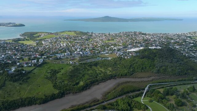 Aerial view of Auckland suburb with Rangitoto Island in the background, New Zealand. The scene shows Mission Bay residential area and the island in the distance.