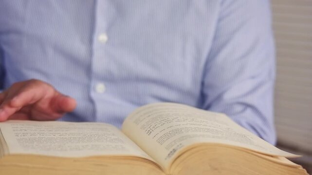 Opening a book to search for specific information, educational learning in literary textbooks in academic fields at the reading table in the school library classroom. Cognitive knowledge and learning.