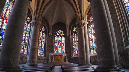 Colorful stained glass windows cast vibrant light onto the altar and pews within a serene church interior, creating a peaceful and spiritual atmosphere - Powered by Adobe