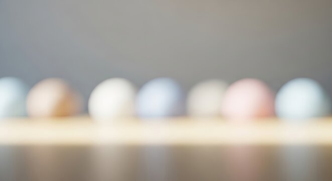 A row of colorful Easter eggs on a wooden table against a gray background. - Powered by Adobe