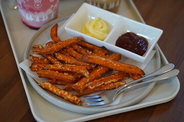 Crispy Sweet Potato Fries Served with Dipping Sauces on a Plate for Tasty and Satisfying Snack Experience in a Cozy Dining Environment