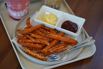 Crispy Sweet Potato Fries Served With Dipping Sauces On A Plate In A Warm Restaurant Setting