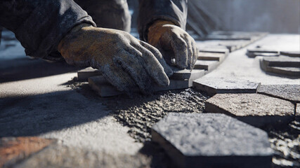 Craftsman carefully installing stone pavers for modern patio