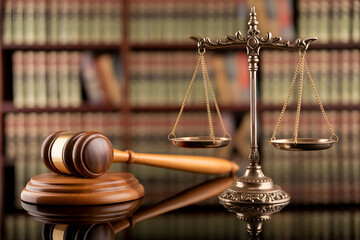 Gavel and scales of justice symbolize law and order in a courtroom setting with a backdrop of legal books representing legal profession justice system and legal representation