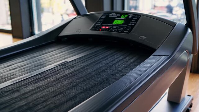 Treadmill console displaying increasing time, speed, distance, and calories metrics in sunlit, empty fitness space with modern digital interface