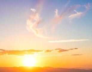 Vibrant sunset casts golden light on distant mountains under a serene sky with wispy clouds