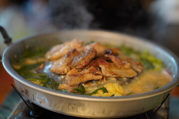 Freshly Cooked Chicken and Vegetables in Hot Pot with Steaming Broth in Traditional Asian Culinary Setting