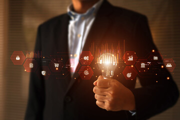 Businessman's hand is choosing light bulb with business creativity icons for plan to goal or creative idea innovation or analyzing marketing data management and target growth or human resources.