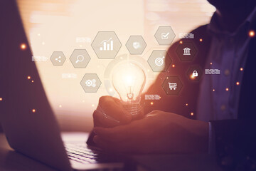 Businessman's hand is choosing light bulb with business creativity icons for plan to goal or creative idea innovation or analyzing marketing data management and target growth or human resources.