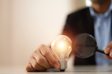 Businessman's hand is choosing light bulb for business creativity plan to goal or creative idea innovation or analyzing marketing data management and target growth or human resources.