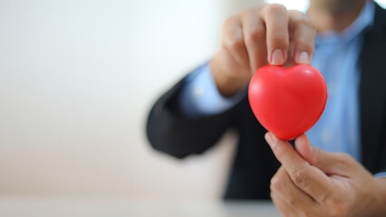 The doctor's hand is choosing the heart for medical health care for safety insurance for sick...