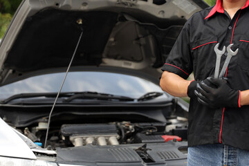 Car mechanic holding wrench for fix service repairing change spare part engine problem or insurance support or range of car check or training workshop and auto care maintenance servicing concepts.