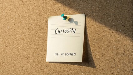 Inspiring Note on Corkboard Highlighting Curiosity as a Driver of Discovery and Innovation in Creative Workspaces
