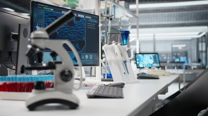 close up of microscope in lab next to computer monitor displaying DNA data and mole - Powered by Adobe