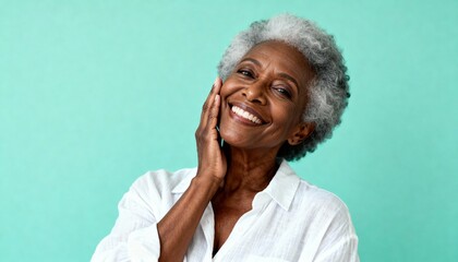 Happy senior African American woman with gray curly hair smiling confidently and touching her cheek, radiating joy and positive emotion on a bright, solid teal background, a beautiful wellness portrai